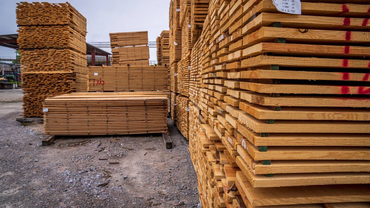 Bois de construction empilé dans la cour d’un négoce de matériaux