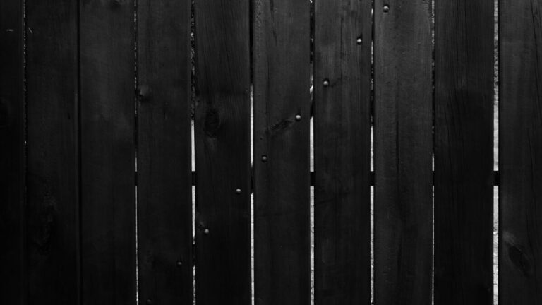 Claustra en lames de bois verticales séparant deux parties d’un jardin